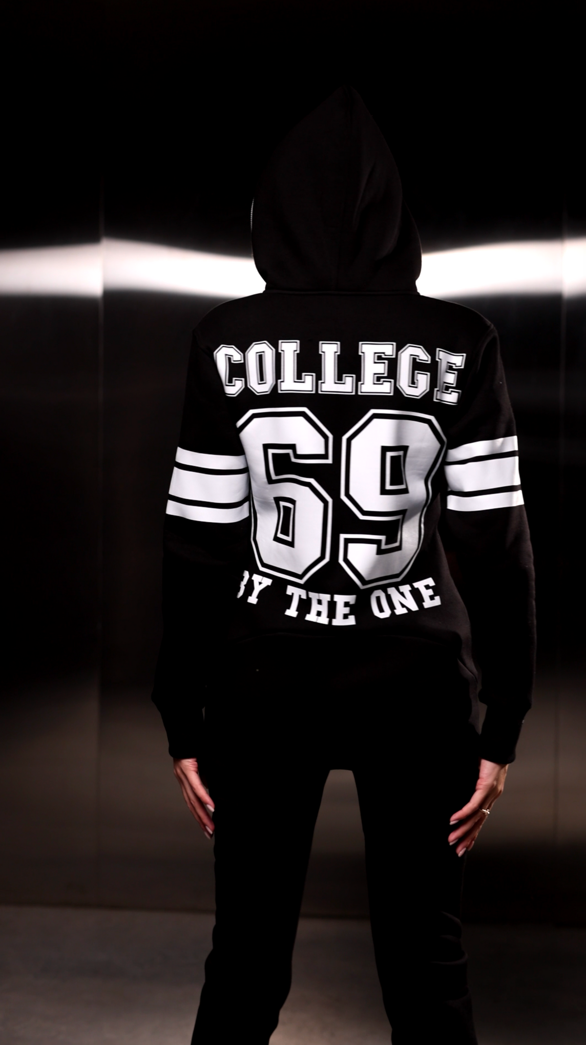 Warm jumpsuit 69 black, back view: COLLEGE 69 print and hood | THE ONE