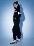 69 black jumpsuit, side view: striped sleeves, fitted silhouette | THE ONE