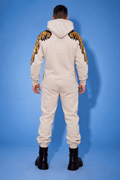 Angel beige jumpsuit, back view: gold wings on the sleeves, inverted-triangle silhouette | THE ONE