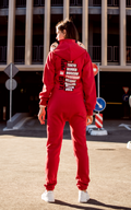 Warm jumpsuit Casa de papel red, back view: city names print, outdoors in the city | THE ONE