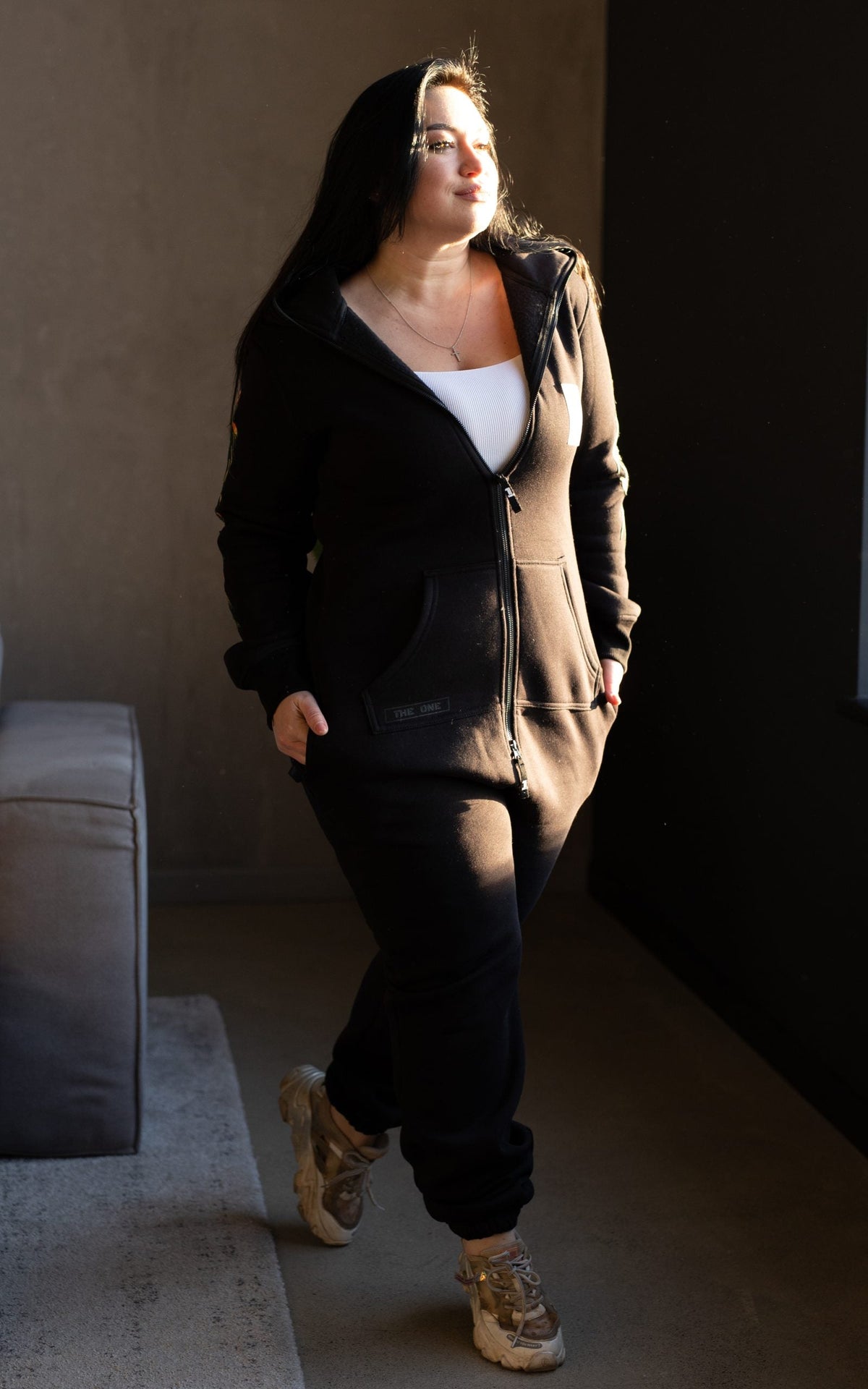 Firebird black jumpsuit unzipped with a white top: one-piece silhouette that fits | THE ONE