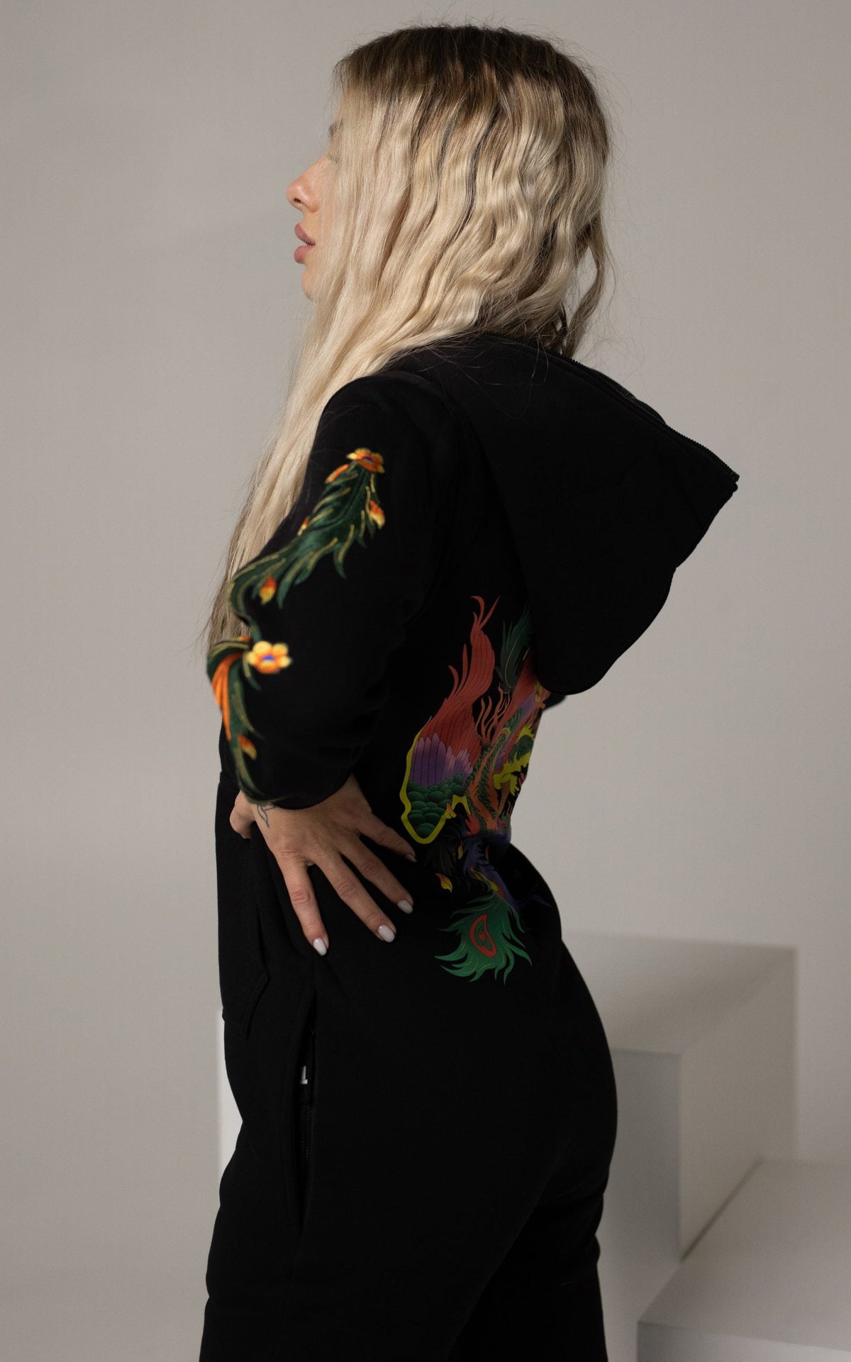 Firebird black jumpsuit on a woman, side view: embroidery on the back and sleeves | THE ONE