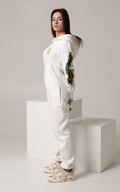 Firebird white jumpsuit on a woman, side view: embroidered sleeves | THE ONE