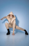 Ninja beige jumpsuit in a deep squat: lower back covered | THE ONE