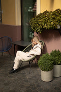 Ninja beige jumpsuit sitting in a cafe chair: comfortable, nothing presses | THE ONE