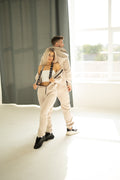 Couple in beige Ninja jumpsuits on suspenders, tops lowered (option on request) | THE ONE