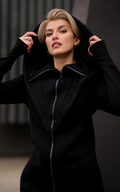 Ninja black jumpsuit close-up: oversized hood, high collar, thumbhole cuffs | THE ONE