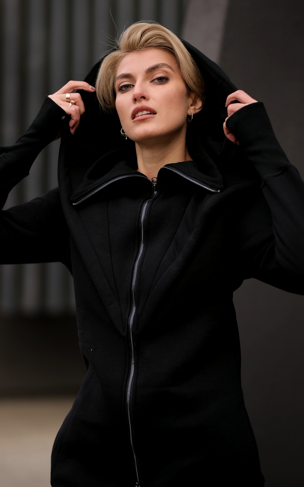Ninja black jumpsuit close-up: oversized hood, high collar, thumbhole cuffs | THE ONE