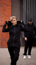 Ninja black jumpsuits for her and him on a city street, matching look | THE ONE