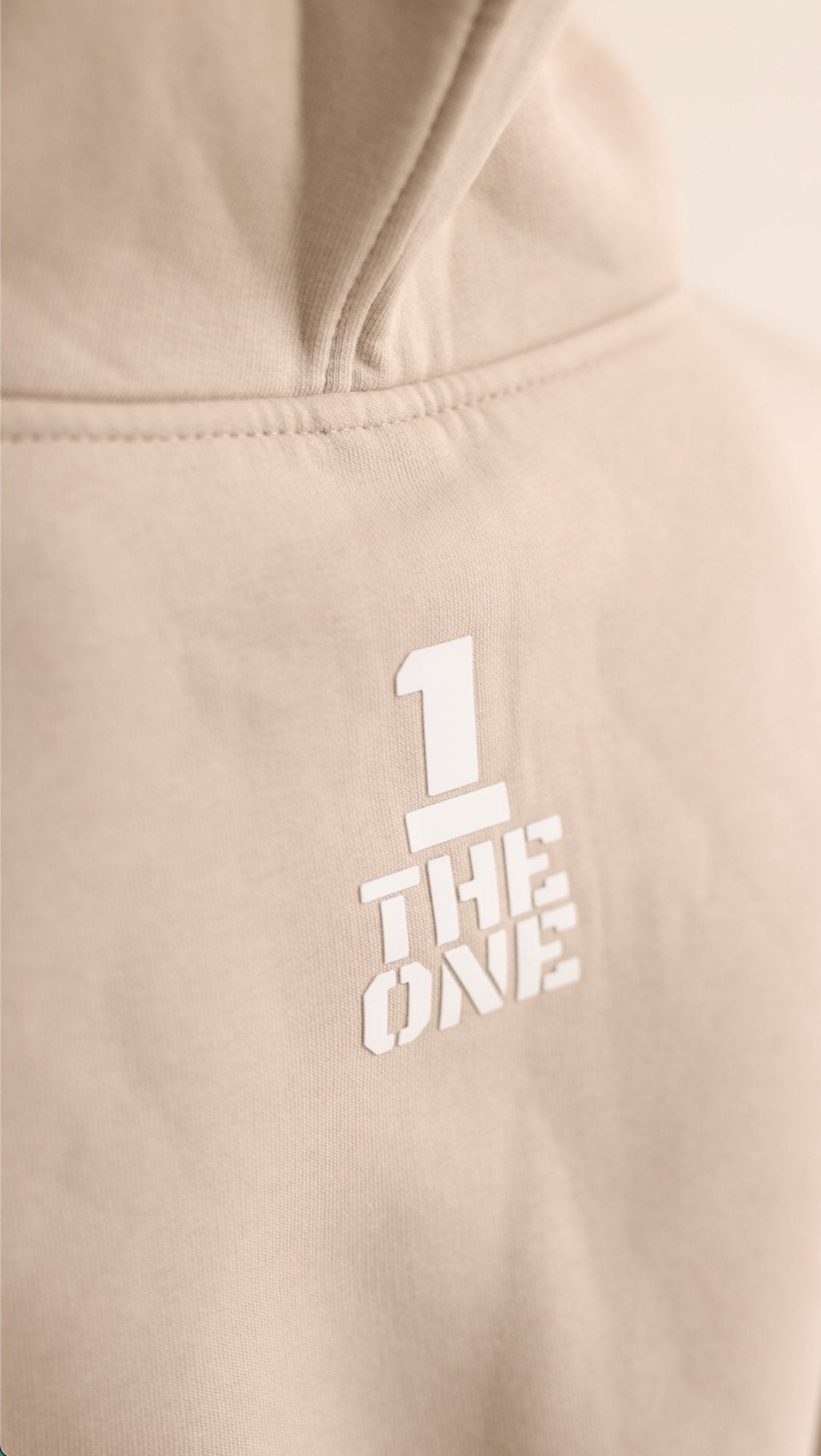 THE ONE print on the back of the Original beige jumpsuit, close-up | THE ONE