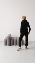 Original black jumpsuit, back view: one-piece cut, lower back covered | THE ONE
