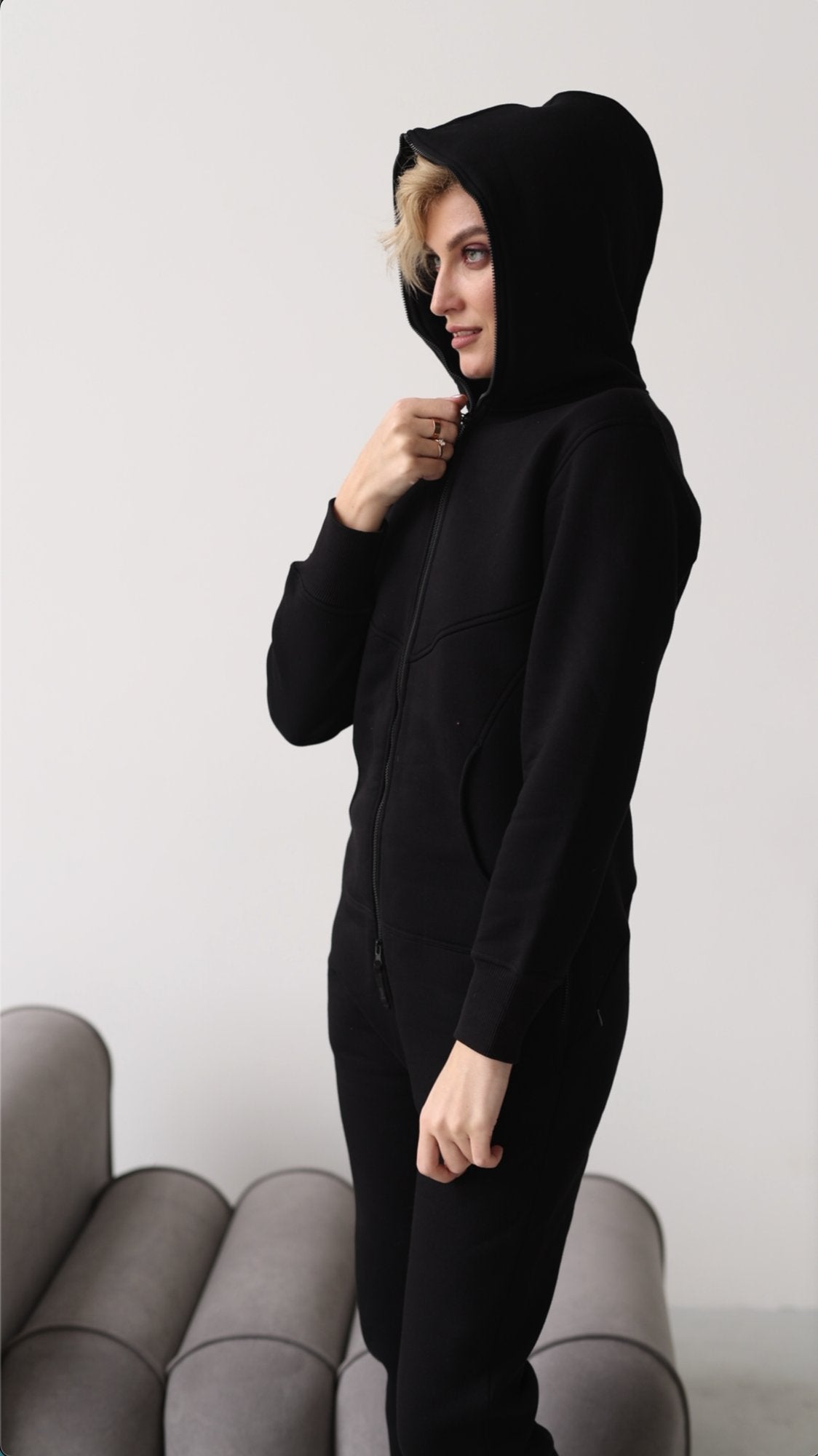 Original black jumpsuit with hood up, side view | THE ONE