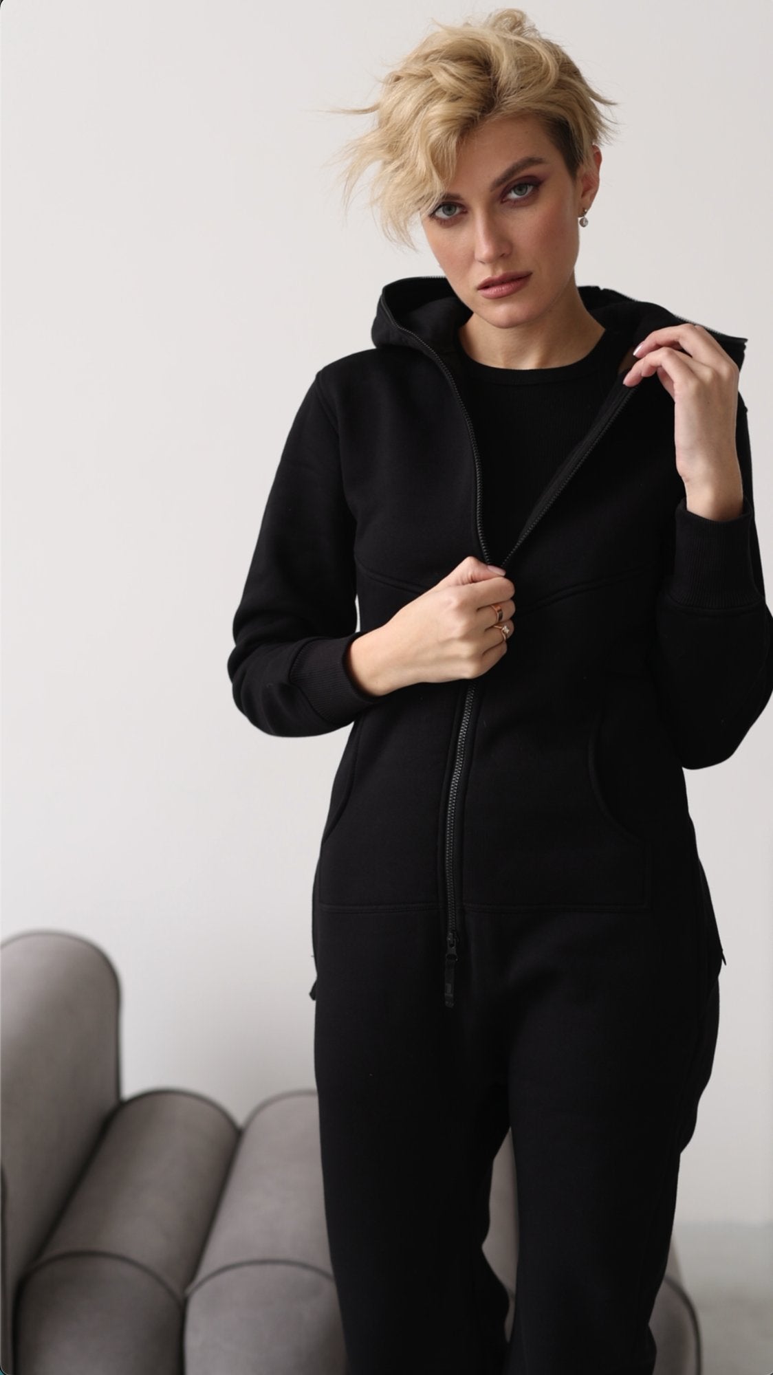 Original black jumpsuit unzipped at the chest over a black top | THE ONE