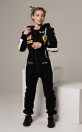Race black jumpsuit on a slim woman: racing stripes, cuffed legs, hourglass silhouette | THE ONE
