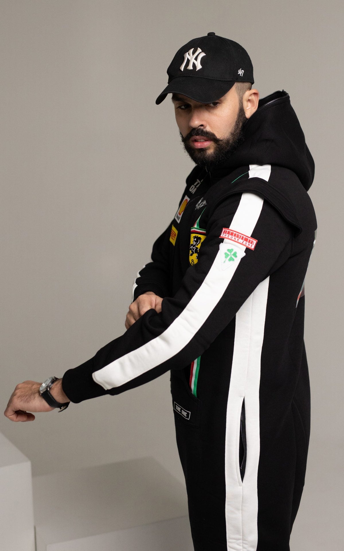 Men's Race black jumpsuit, side view: white racing stripes on the sleeves and legs | THE ONE